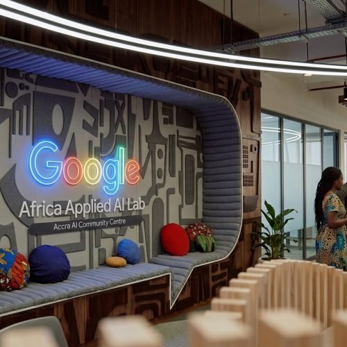 Développeurs africains collaborant dans un hub technologique à Accra autour de solutions d'intelligence artificielle.